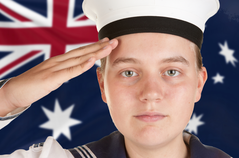 Young,Female,Sailor,Saluting,In,Front,Of,Australian,Flag